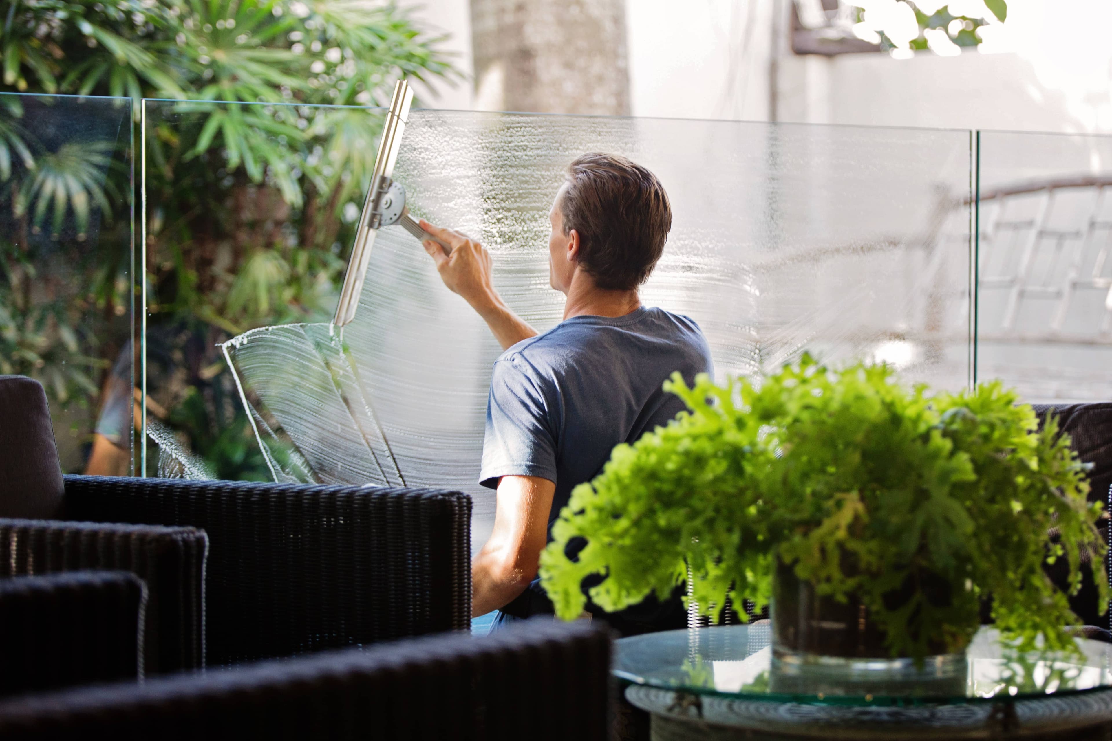 Man cleaning a window in an office